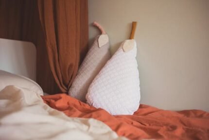 Warm and inviting bedroom interior with creative pear-shaped cushions adding a playful touch.